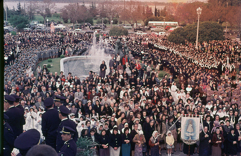 Gran multitud reunida alrededor de la fuente del Parque Nacional a la Bandera, con un estandarte religioso entre la gente, Rosario, 1957.